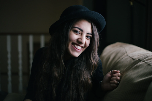 image of girl in a hat laughing with a wide grin smile showcasing her strong and white teeth