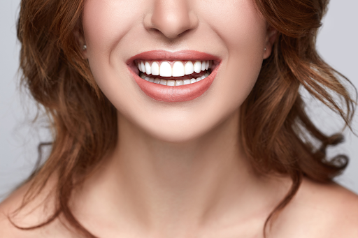 a redhead girl smiling with white shining teeth