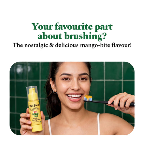 Smiling woman holding the Mango Bite Inspired Toothpaste and a loaded toothbrush